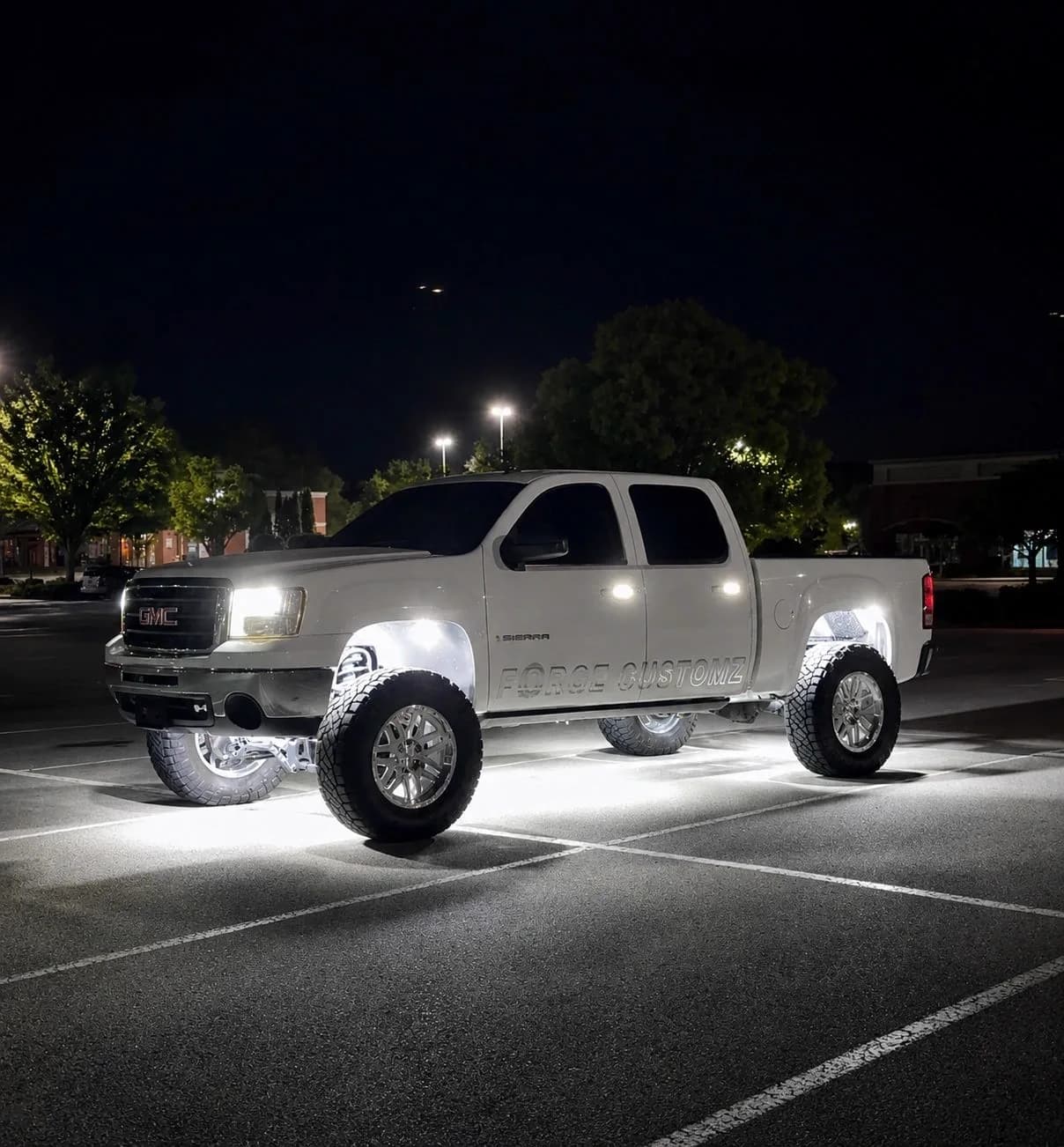White GMC Sierra lit from underneath by high density white LED rock lights at night