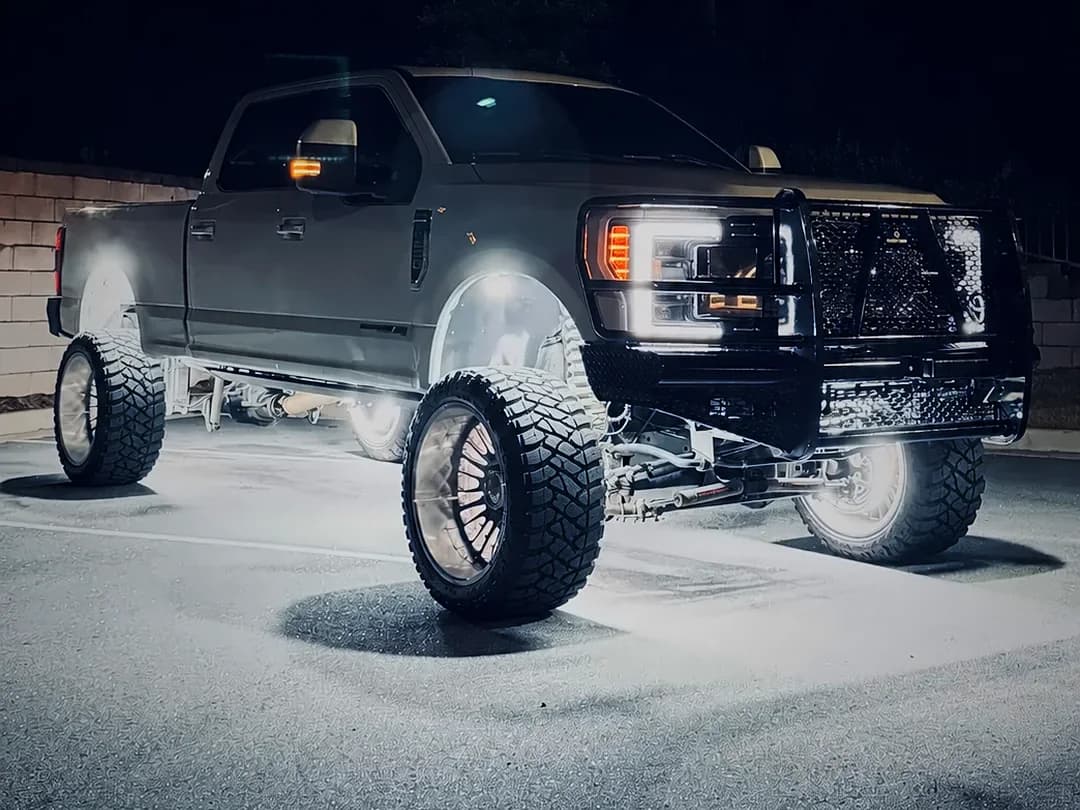 Ford F250 Lariat Super Duty at night with rock lights and ultra bright wheel lights