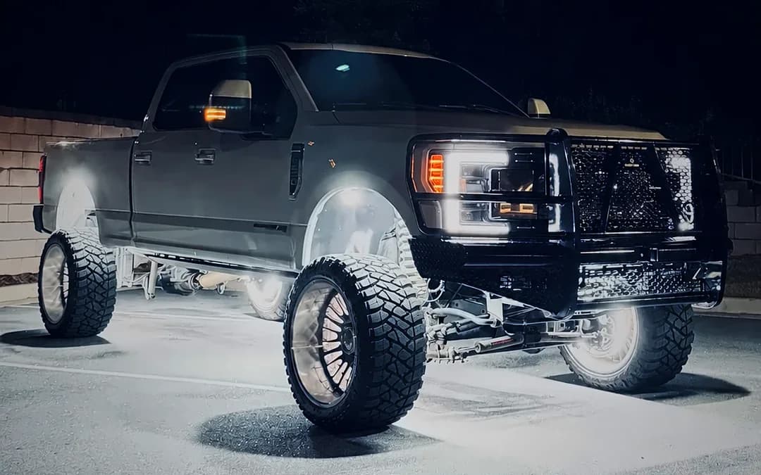 Ford F-250 at night with wheel lights, grille guard and a full accessory package